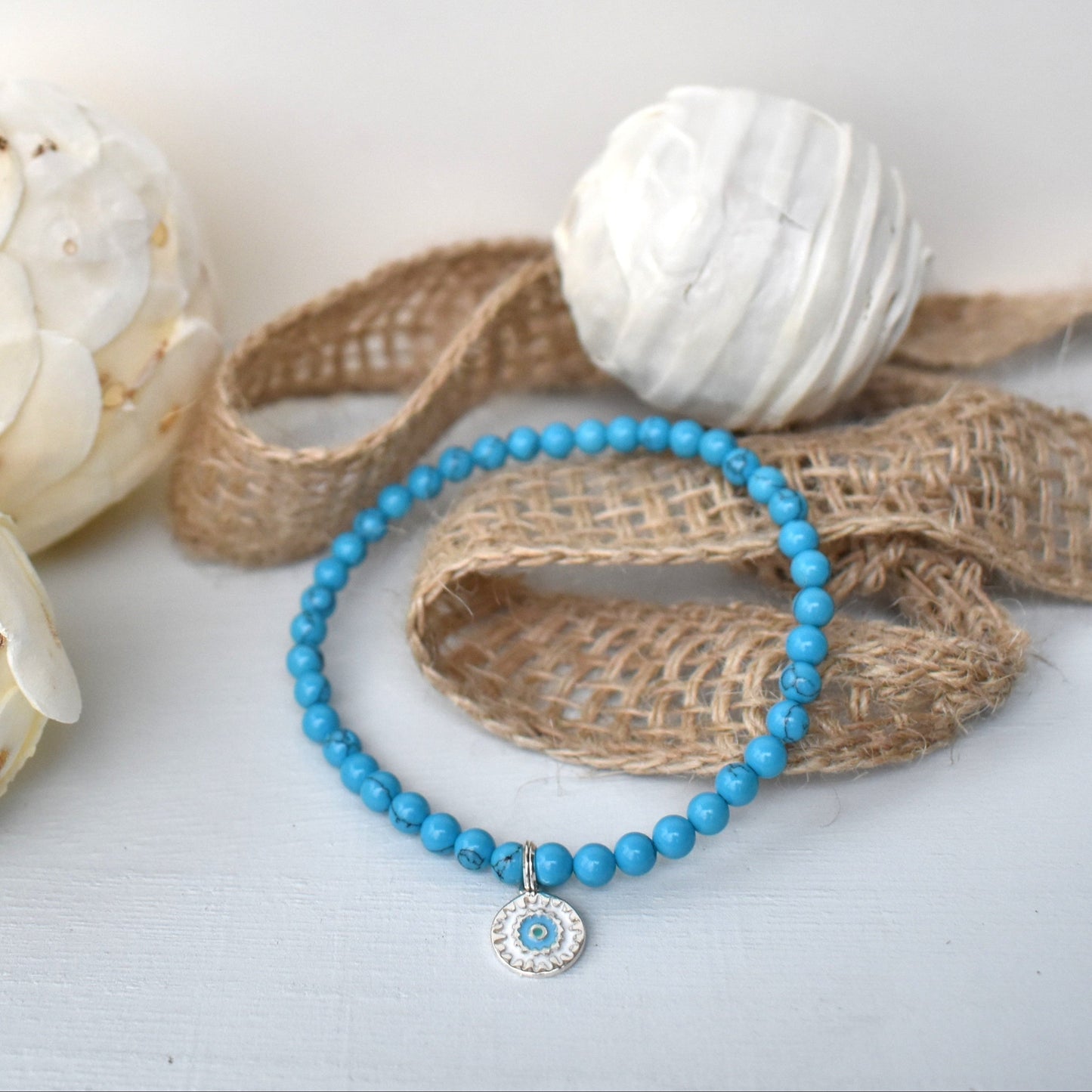 Elasticated bracelet with 4mm reconstituted turquoise beads and a perfect sterling silver mandala charm, make the perfect beach bracelet.