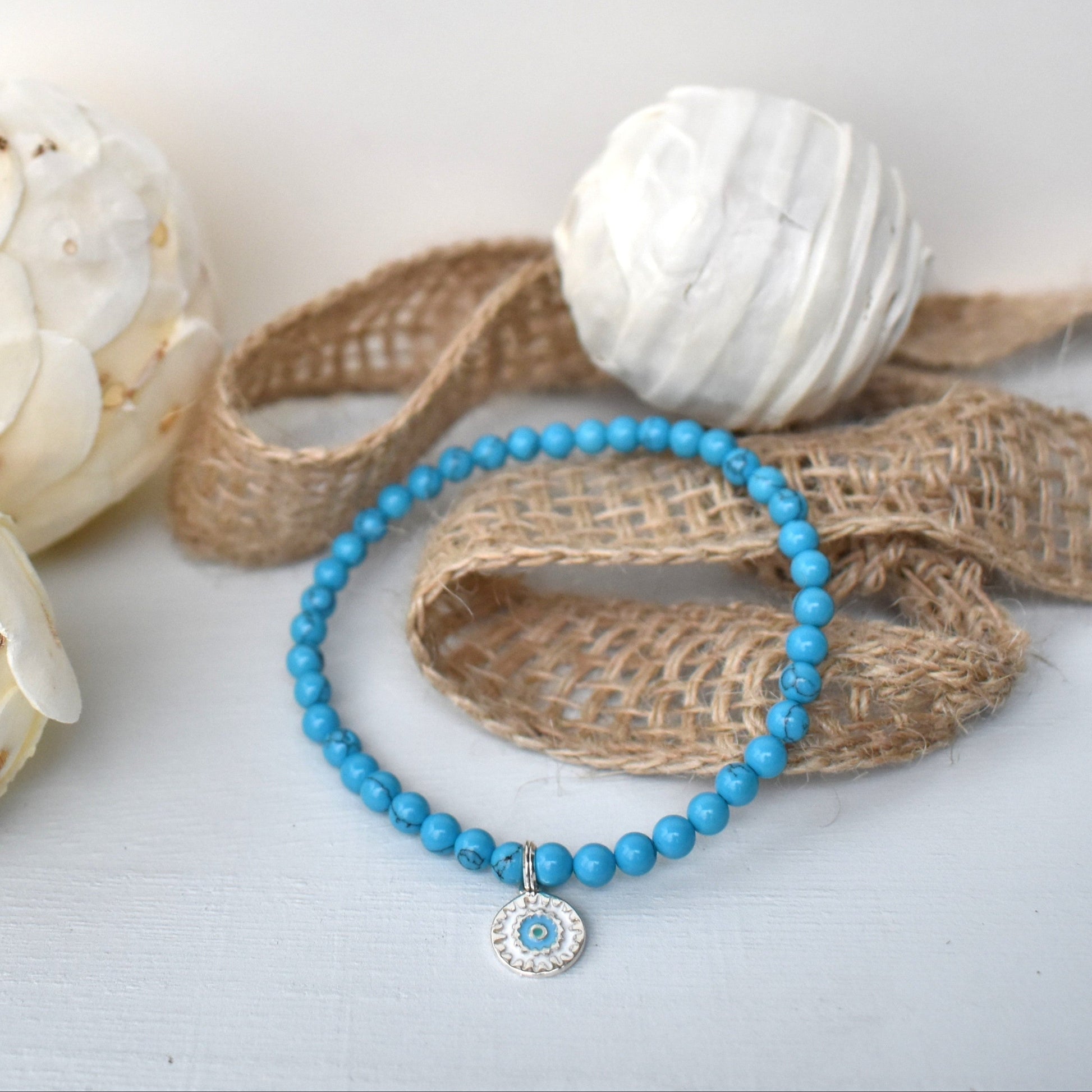 Elasticated bracelet with 4mm reconstituted turquoise beads and a perfect sterling silver mandala charm, make the perfect beach bracelet.