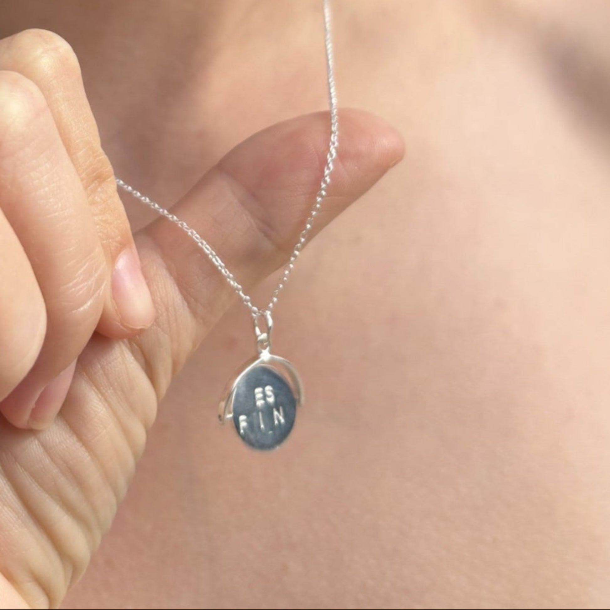 Sterling silver spinner necklace with lettering either side. When spon is forms the words "Best Friend"