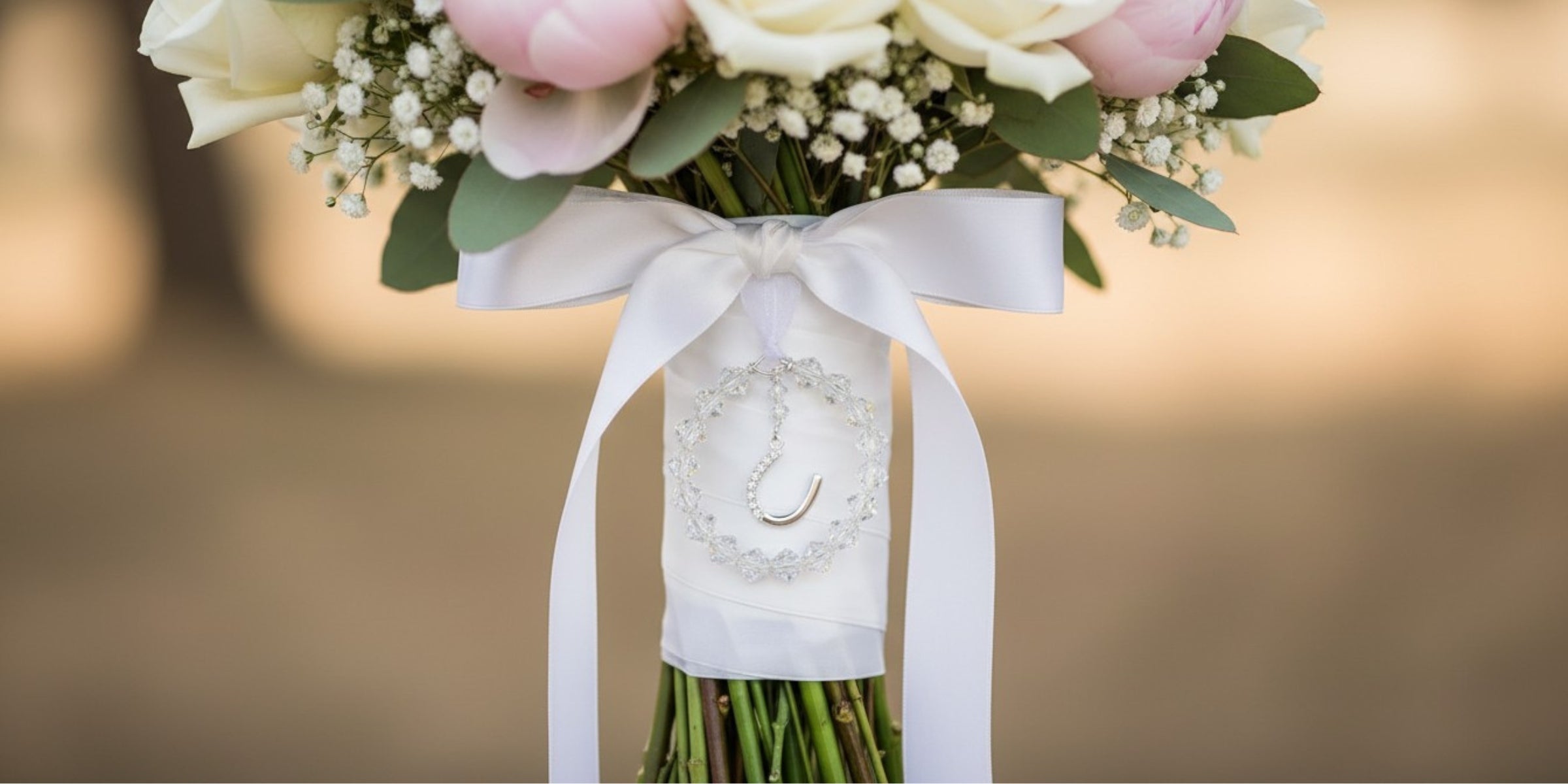 crystal and sterling silver horseshoe bouquet charm shown on wedding bouquet
