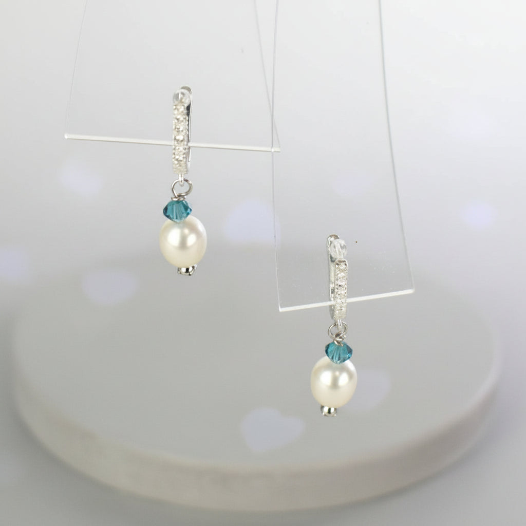 freshwater pearl earrings with aqua Austrian crystals hung from ssterling silver ear wires trimmed with diamante