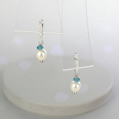 freshwater pearl earrings with aqua Austrian crystals hung from ssterling silver ear wires trimmed with diamante