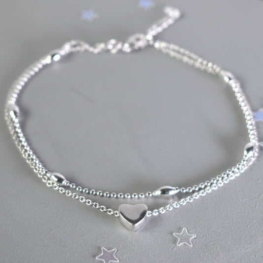 sterling silver double strand beaded anklet with heart centre. Added near the fastening is an optional tiny blue crystal to serve as a bride's "something blue"