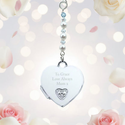 A sterling silver heart shaped locket wedding bouquet charm, engraved with wording of your choice on the front of the heart. The locket opens to add two photos of your choice. Suspended from a string of crystals and glass pearls with a tiny blue bead for your something blue.