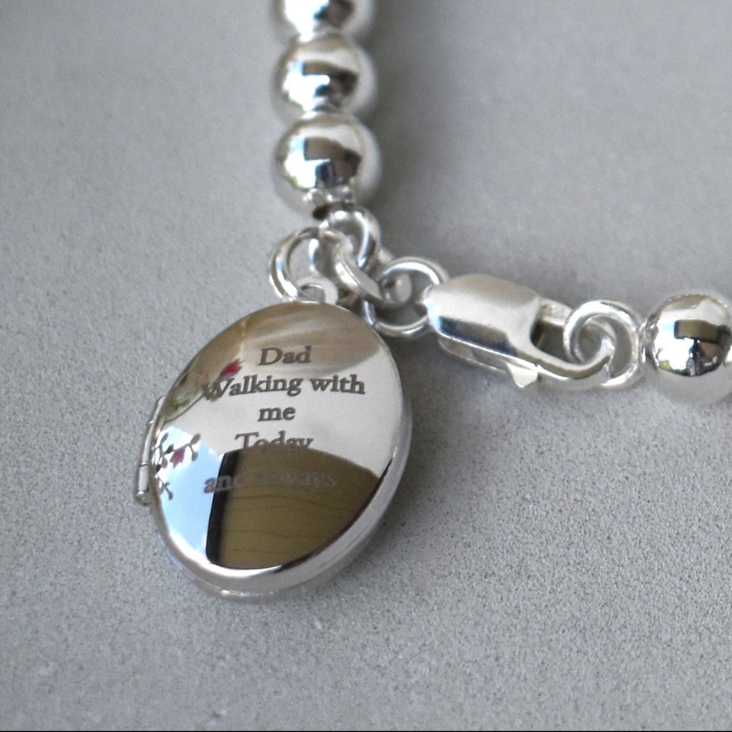 6mm sterling silver ball bracelet. Next to the lobster fastening is a sterling silver engraved locket which can be engraved with up to five lines of text for your own message. 