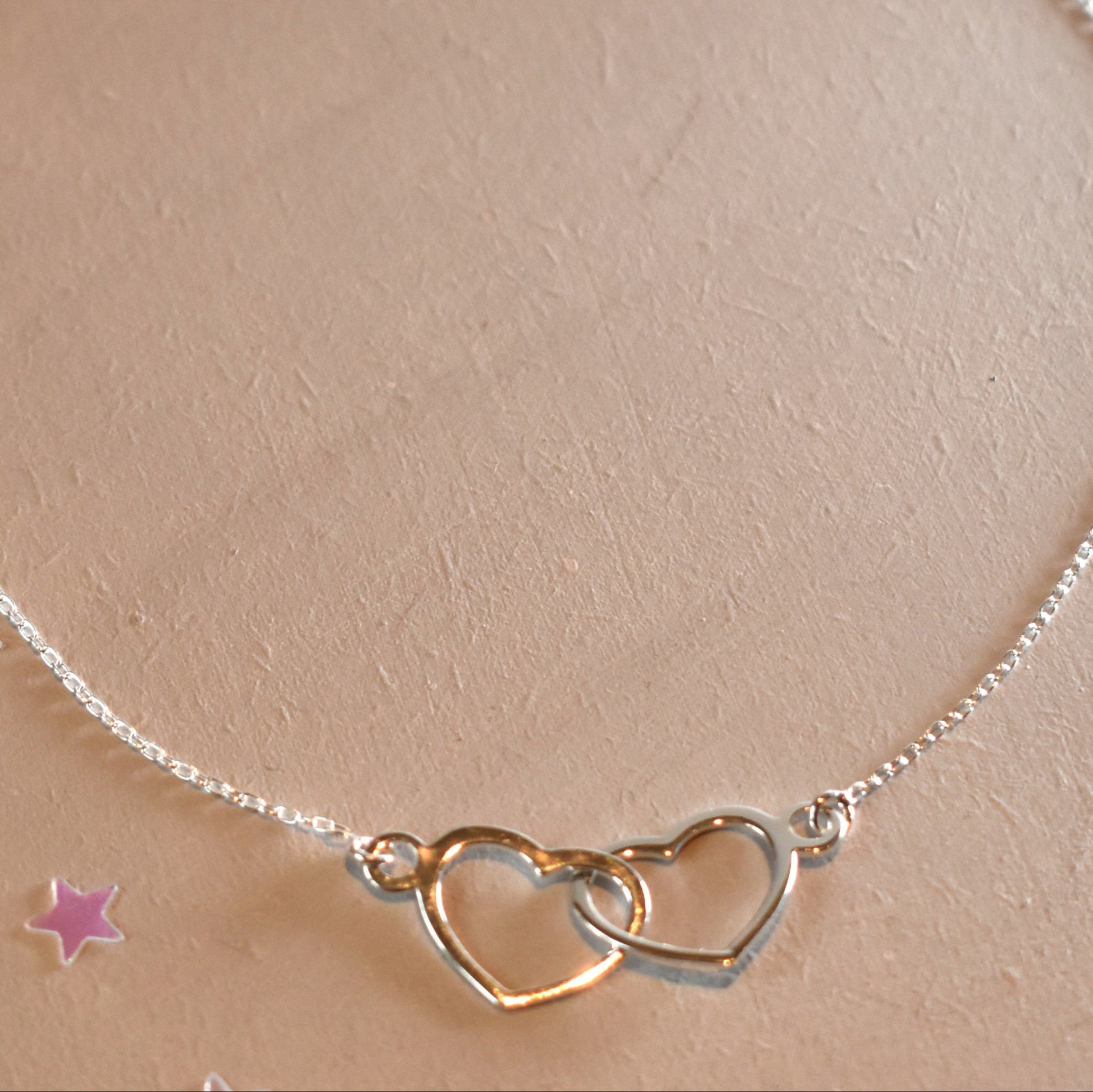Sterling silver necklace with entwined hearts link. 
