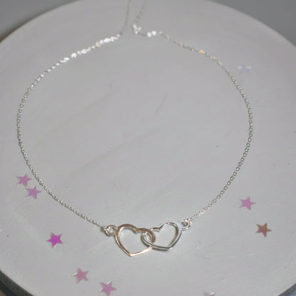 Sterling silver necklace with entwined hearts link. 
