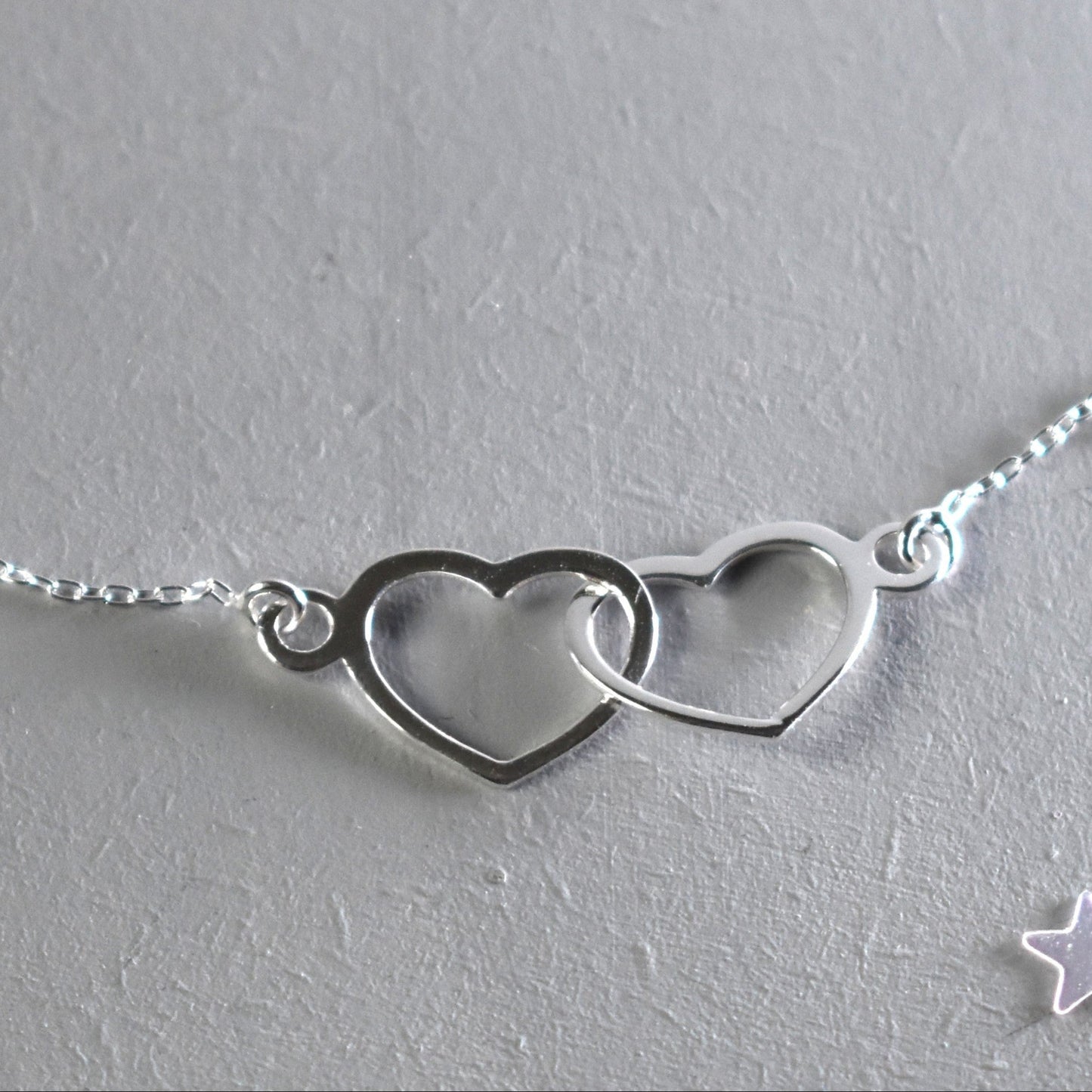 Sterling silver necklace with entwined hearts link. 
