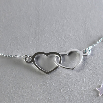 Sterling silver necklace with entwined hearts link. 
