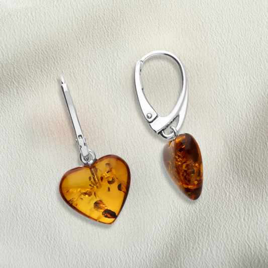 Pair of amber heart-shaped earrings on a light background