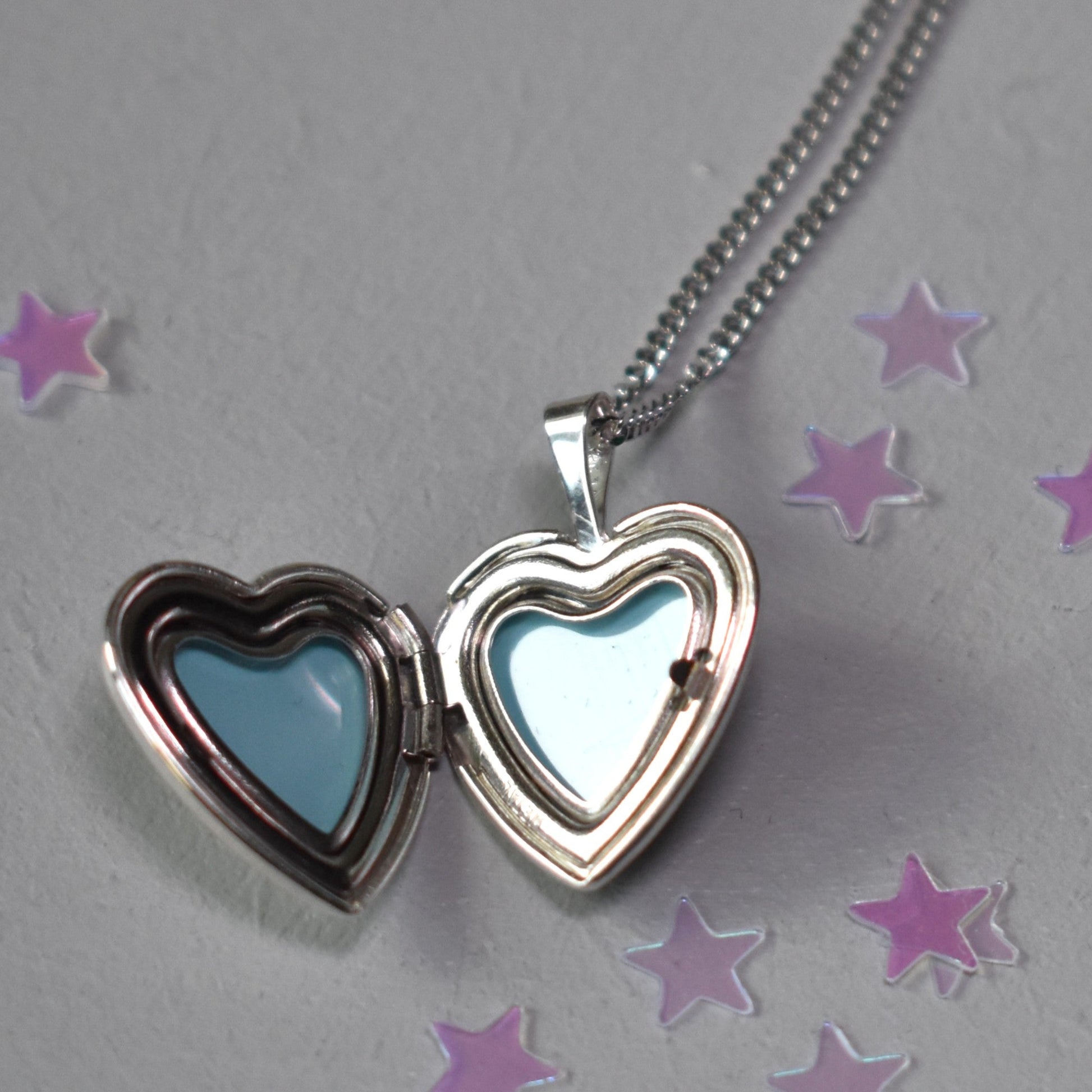 Heart shape locket opens to hold two photographs