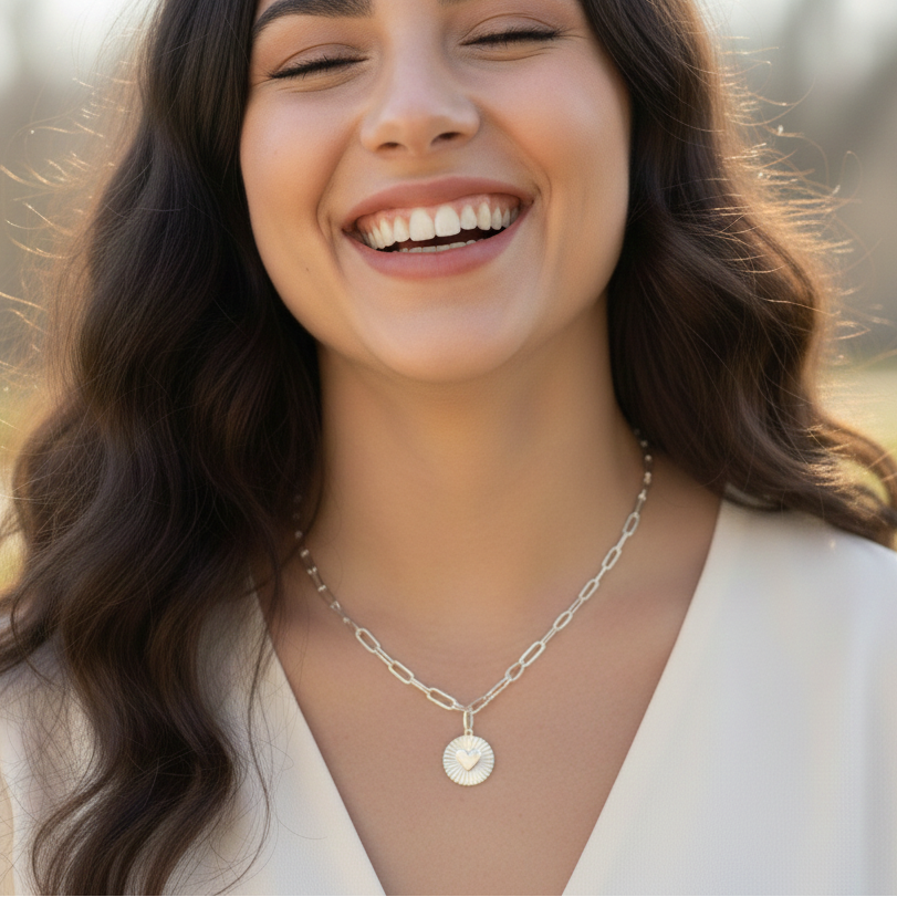 Model wears Sterling silver infinity link necklace with sunburst pendant