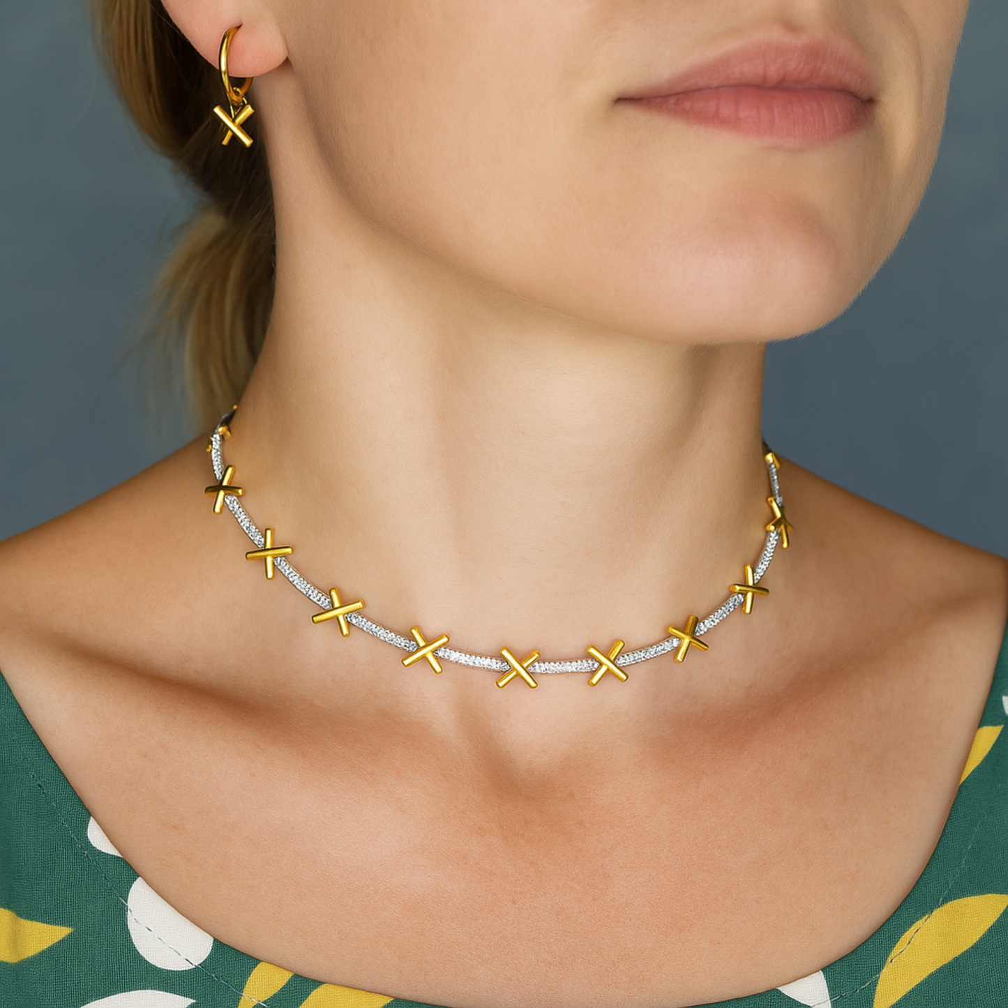 A delicate sterling silver necklace with gold plated kiss charms separated by sparkling CZ stones. Comes with small extension chain