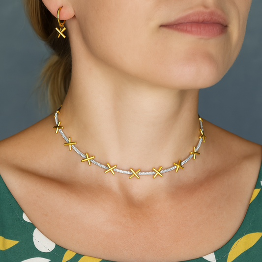A delicate sterling silver necklace with gold plated kiss charms separated by sparkling CZ stones. Comes with small extension chain