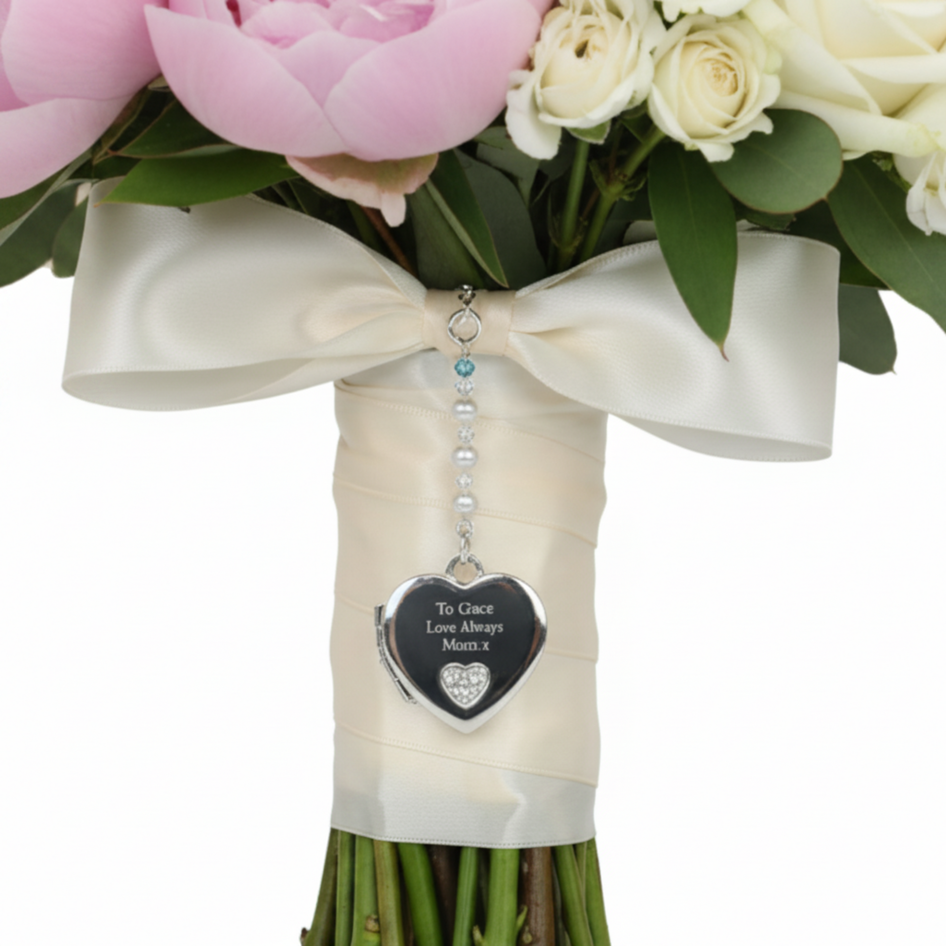 Sterling silver heart shaped locket wedding bouquet charm. Shown on wedding bouquet. Suspended from a string of crystals and glass pearls with a tiny something blue bead