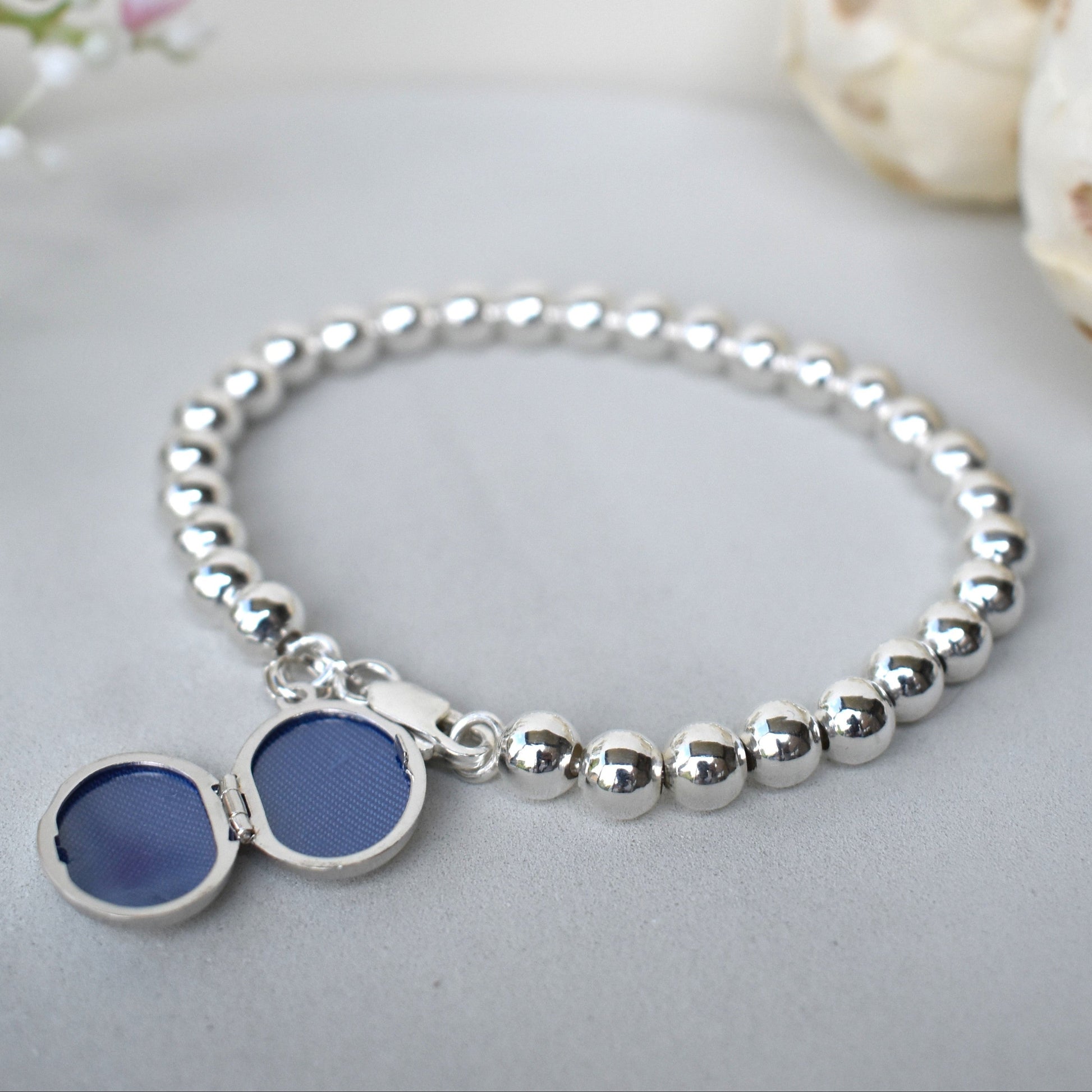 The locket on the sterling silver bracelet opens to include up to two photographs