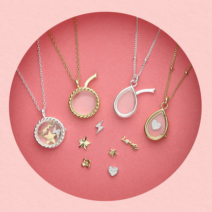 Collection of glass locket necklaces in gold and silver with interchangeable mini charms including stars, hearts, lightning bolt, and 'love' text charm,