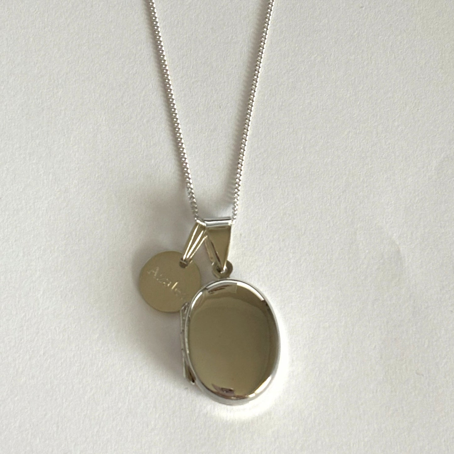 Oval locket shown with round engraved tag