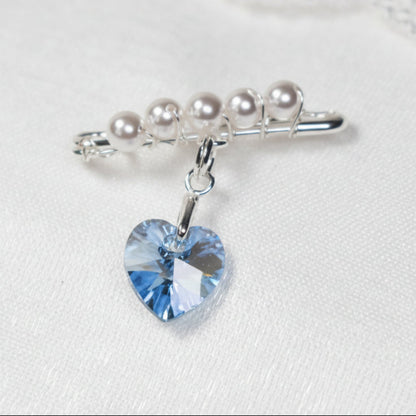 A sterling silver safety pin is finished with 4mm white glass pearls The loop on the pin hold a sterling silver bail with the highest quality blue crystal heart. The pin can be pinned to a wedding bouquet or worn inside the wedding gown as a secret something blue.