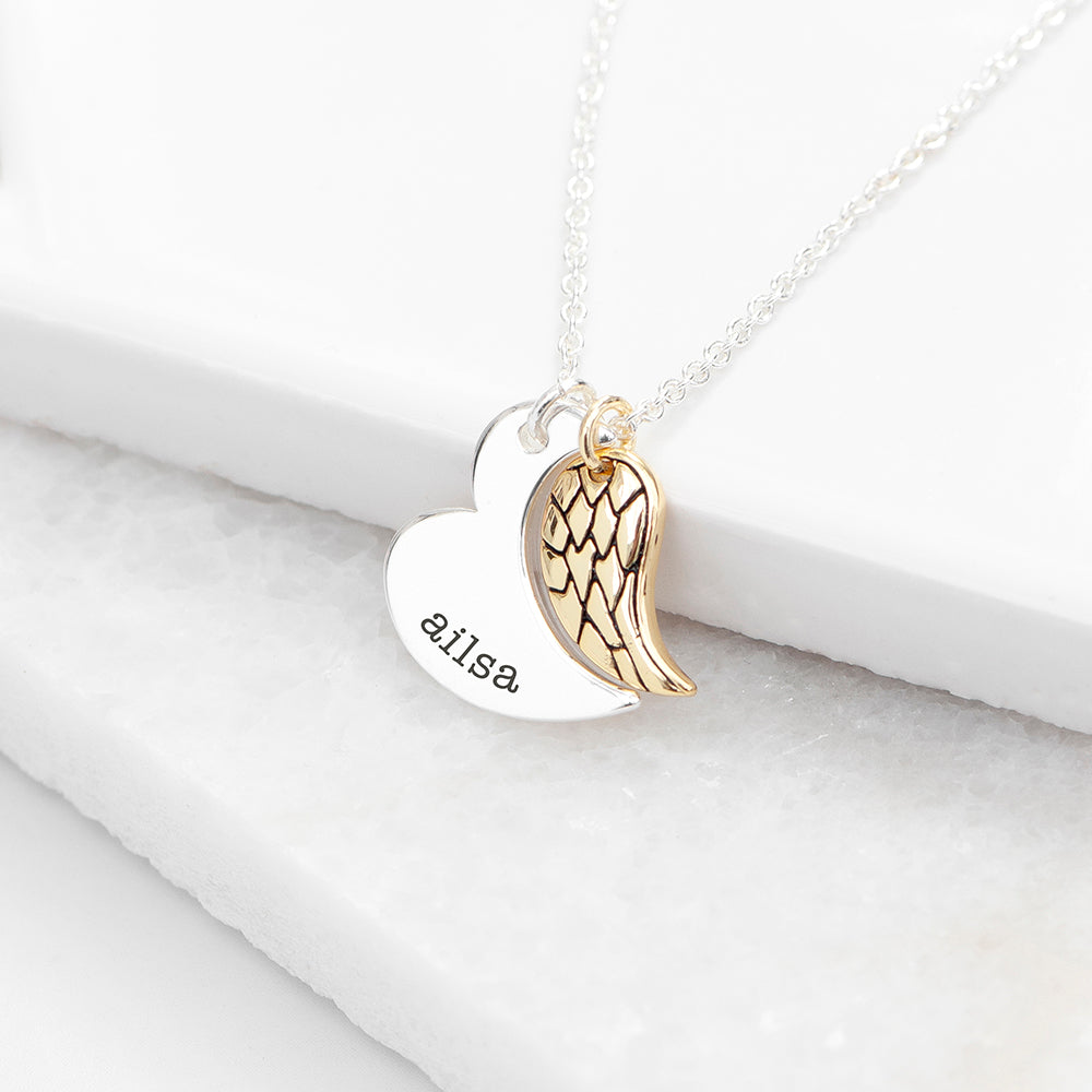 Gold plated angel wing charm is hung next to a partially formed silver plated heart. Together they complete the heart shape. Silver part of heart can be engraved with a name of your choice.