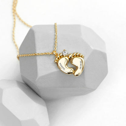 Personalised baby feet necklace. Engraved with baby’s name and date of birth on adjustable necklace. Shown in gold plate.