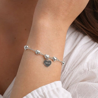 A bracelet of puffed hearts linked by a twisted chain. An engraved heart is added to the bracelet with wording of your choice