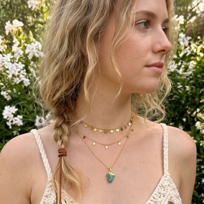 Gold necklace with a raw crystal pendant worn by model