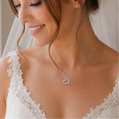 Bride wears a sterling silver heart with a tiny diamante at its base. The heart is suspended directly from a sterling silver chain.