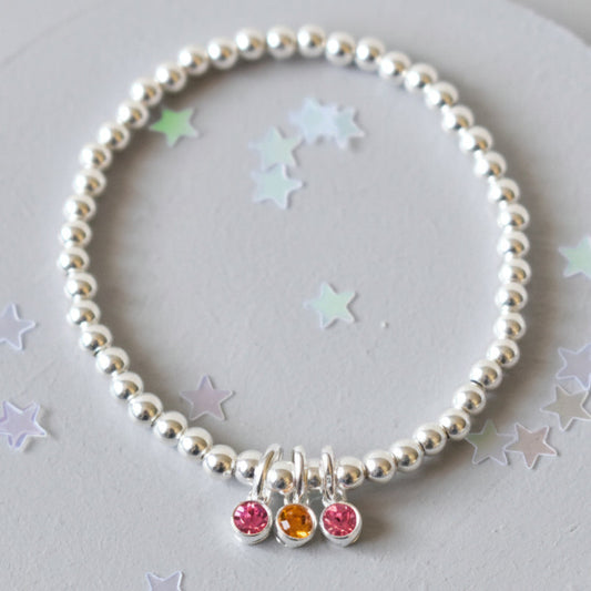 Sterling silver beaded bracelet of 4mm beads threaded onto strong elastic with three birthstones. Up to five birthstones can be added to this bracelet