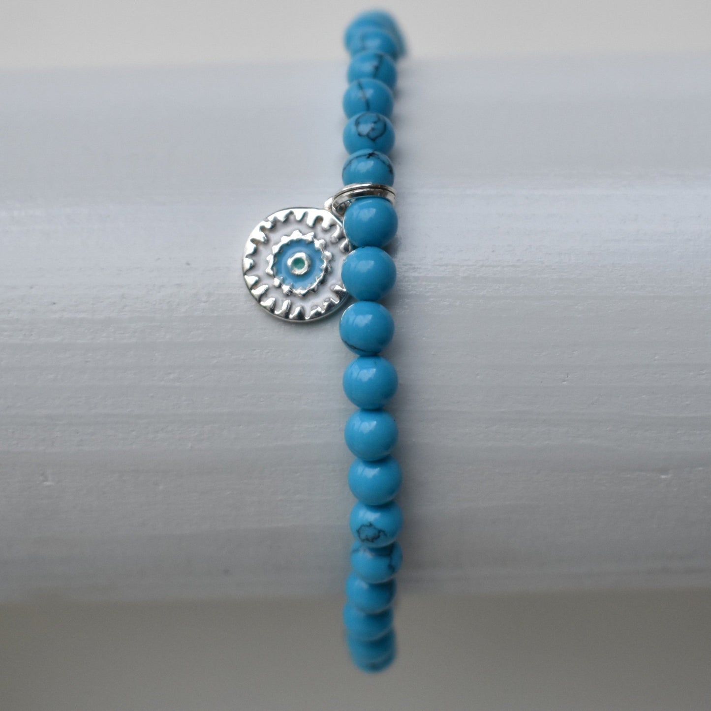 Elasticated bracelet with 4mm reconstituted turquoise beads and a perfect sterling silver mandala charm, make the perfect beach bracelet.