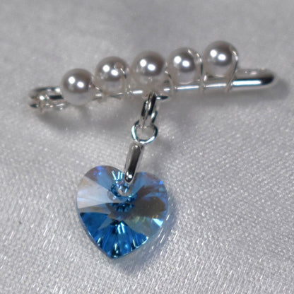 A sterling silver safety pin is finished with 4mm white glass pearls The loop on the pin hold a sterling silver bail with the highest quality blue crystal heart. The pin can be pinned to a wedding bouquet or worn inside the wedding gown as a secret something blue.