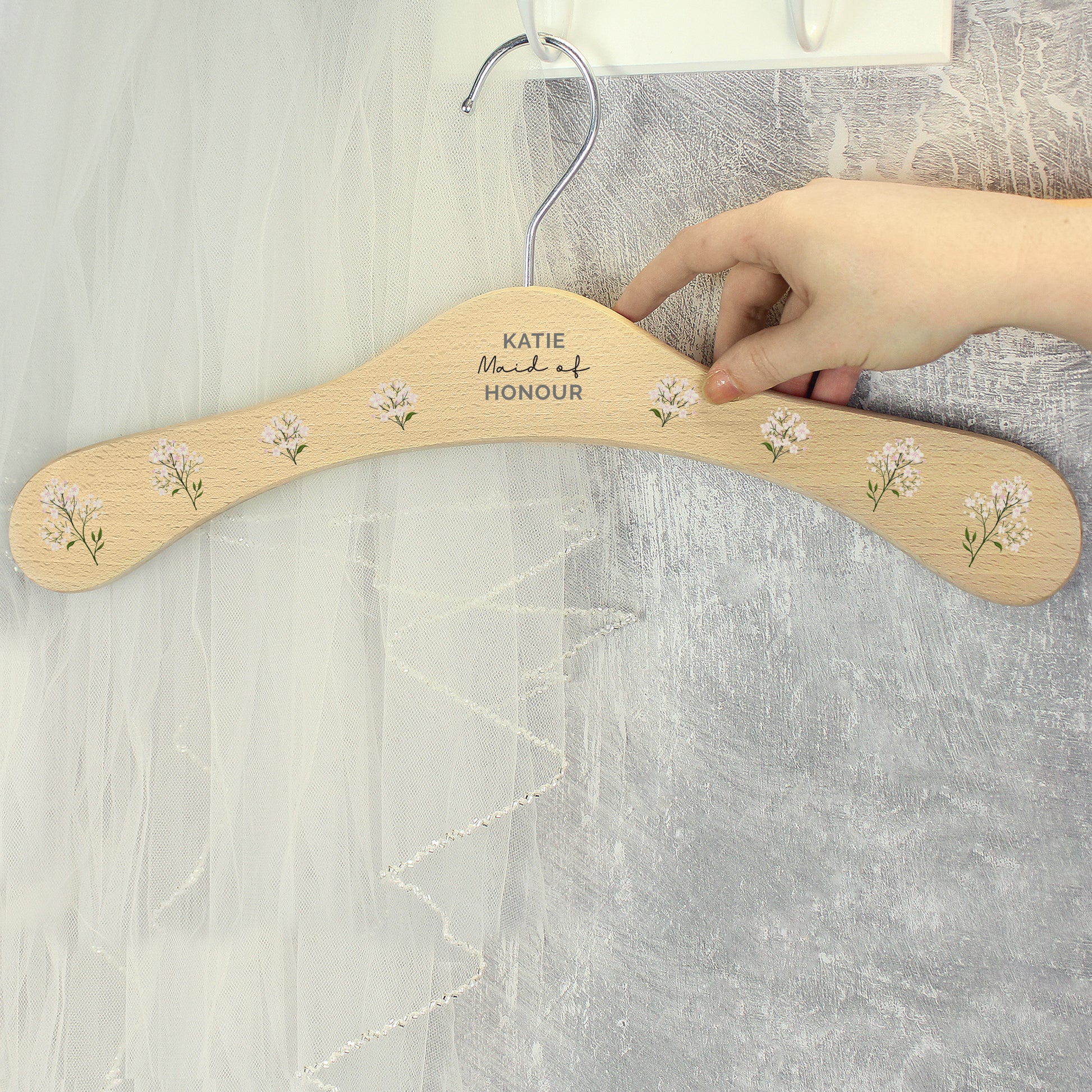 PERSONALISED wooden wedding hanger with three lines of text and flowers along the arms of the hanger