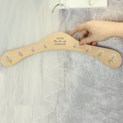 PERSONALISED wooden wedding hanger with three lines of text and flowers along the arms of the hanger
