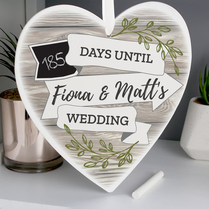 A wooden heart adorned with a wood and leaf finish and a small incorporated chalkboard for you to count down the days to your wedding. Personalised with the names of the happy couple.