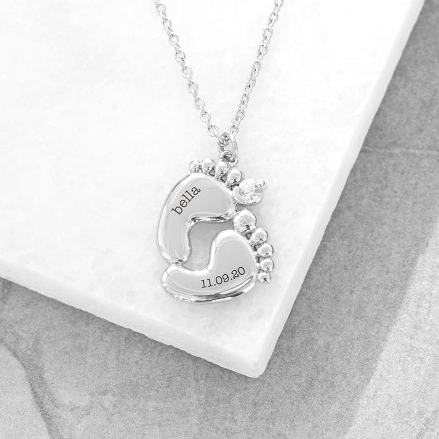 Silver plated baby feet pendant with crystal. One foot has baby's name and the other their birth date