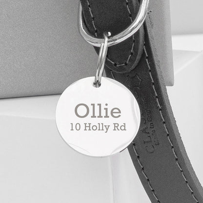 A personalised leather dog collar with an engraved disc attached displaying the name 'Ollie' on a road sign-shaped tag.