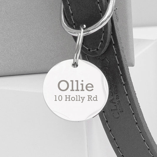 A personalised leather dog collar with an engraved disc attached displaying the name 'Ollie' on a road sign-shaped tag.