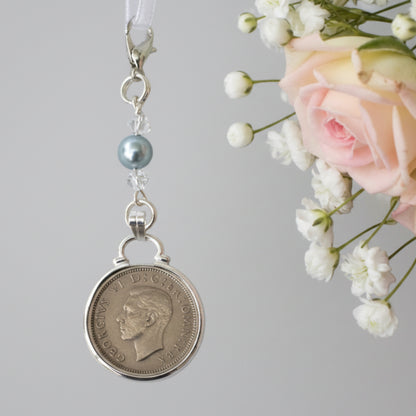 a real sixpence is securely mounted below a line of crystals with a blue bead. Finished with a lobster clasp and ribbon for you to add to your wedding bouquet